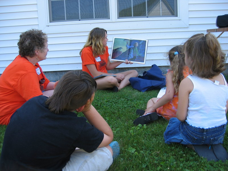 Oxford Hills Bookmobile volunteer Chelsea Marshall reads a story to children as co-worker Betsey Foster, left, looks on. The mobile library will hit the road again beginning June 29.