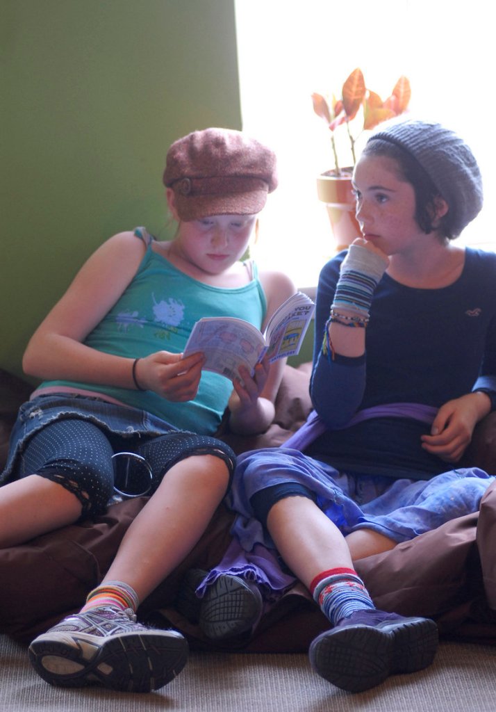 Violet Sulka-Hewes, 10, and Madeline Curtis, 12, both students at the Friends School in Portland, listen to a reading at the Telling Room from “Can I Call You Cheesecake?”