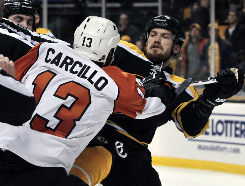 Flyers left wing Daniel Carcillo, left, mixes it up with Boston defenseman Andrew Ference as tempers flare and officials step in Monday night in Boston. The Flyers won, 4-0.