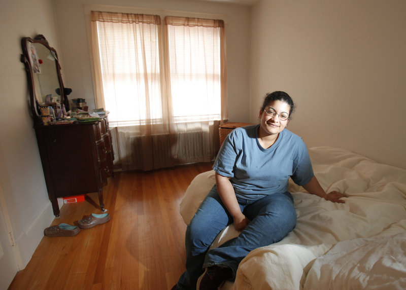 Ivelisse Castro has moved from a homeless shelter into an apartment in Portland with the help of caseworkers and federal funding. Working six days a week, she saved money to buy one of her most cherished possessions in the apartment – the bed she’s sitting on.