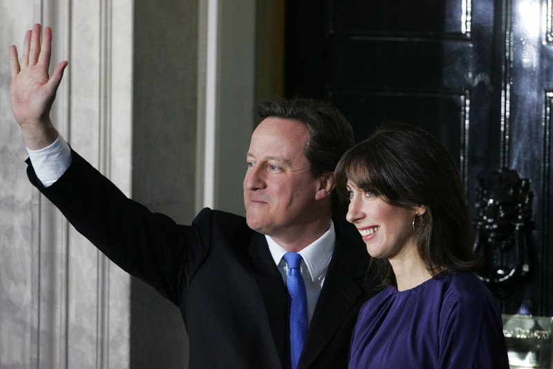 Prime Minister David Cameron and his wife, Samantha, greet the media Tuesday outside 10 Downing Street in London. The residence was vacated earlier by Gordon Brown.