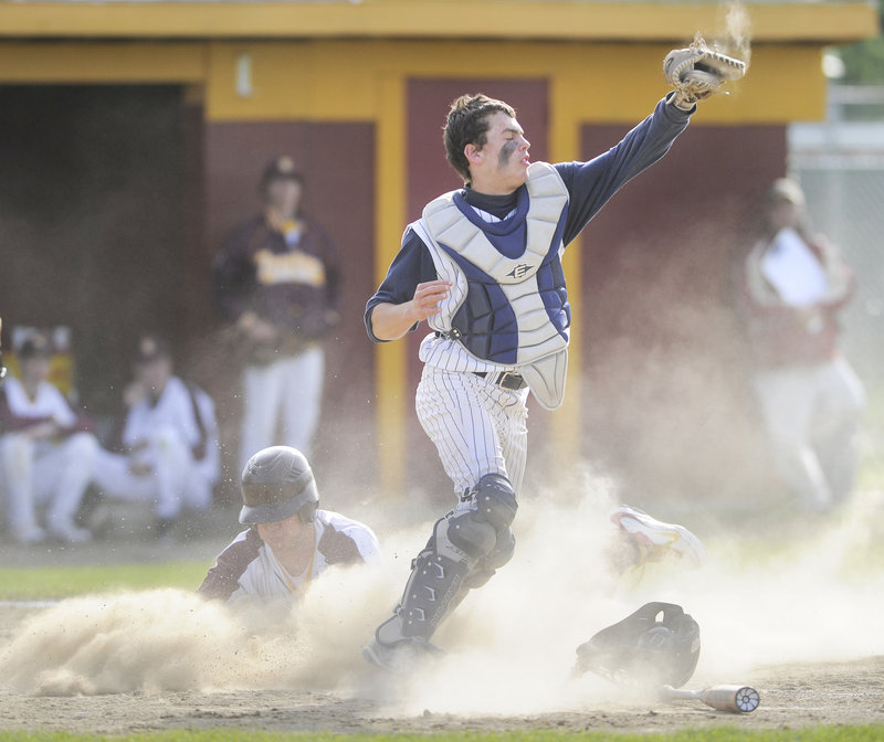 Portland catcher Nick Volger takes the late throw as Steve Trask of Thornton Academy slides in Tuesday during Thornton's 10-2 victory at Saco. The Golden Trojans entered the game as the top-ranked team in Western Class A.