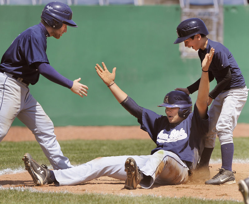 Mike Highland of Penn State Greater Allegheny raises his arms and accepts congratulations after scoring the winning run Tuesday against Southern Virginia in the USCAA tournament at The Ballpark in Old Orchard Beach.