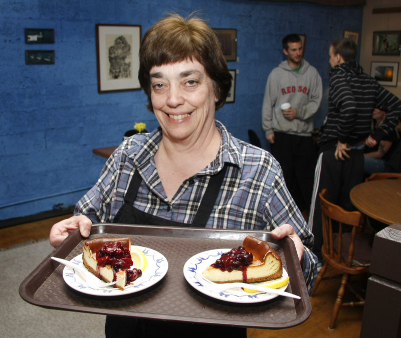 Susan Denyer, co-owner of Mr. Sandwich and Mrs. Muffin on Deering Avenue in Portland, delivers servings of New York cheesecake with fruit compote to a couple of lucky diners.