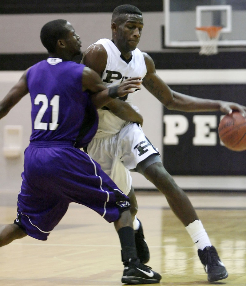 The Odessa Permian High School basketball player who identified himself as Jerry Joseph, right, drives against Midland High’s Paul Merchant during a January game in Odessa, Texas. Police say Jerry Joseph is really Guerdwich Montimere, a 22-year-old naturalized U.S. citizen from Haiti.
