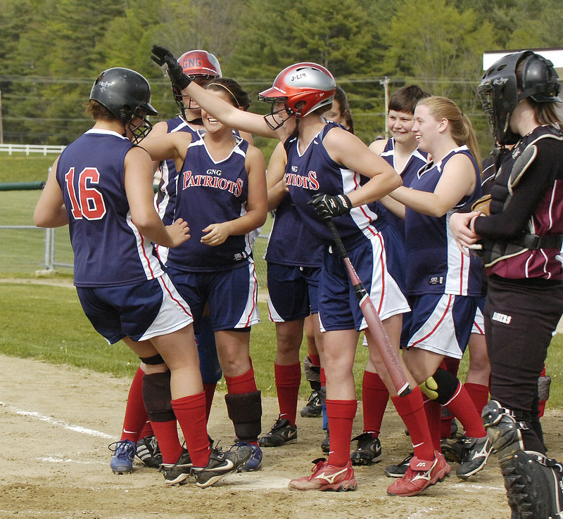Abby Ryan of Gray-New Gloucester, left, gets the welcome home Wednesday after hitting a two-run homer in the first inning against Greely. Ryan later hit a second home run but it was Greely that emerged with a 9-7 victory.