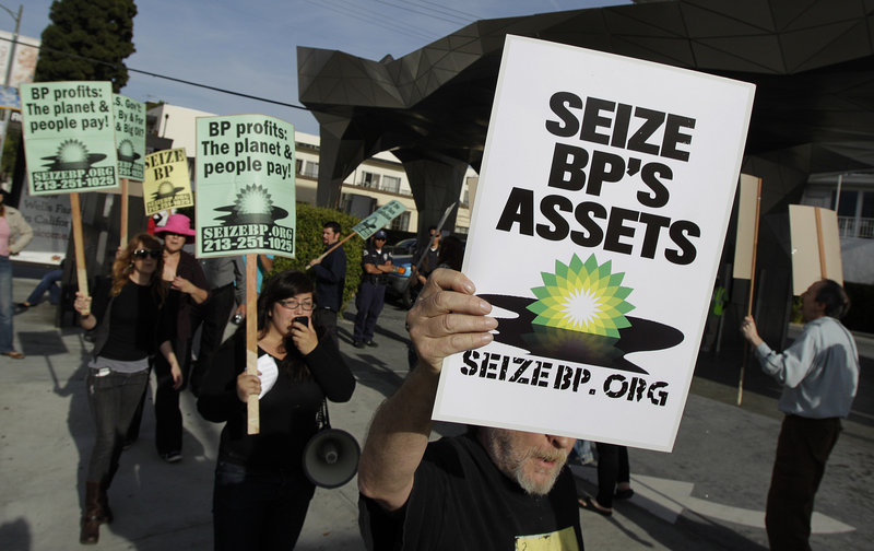 Protesters hold signs outside an Arco gas station during a rally against the Gulf oil rig disaster in Los Angeles on Wednesday. Investigators are trying to learn why proposed federal rules requiring additional measures to prevent spills were never enacted.