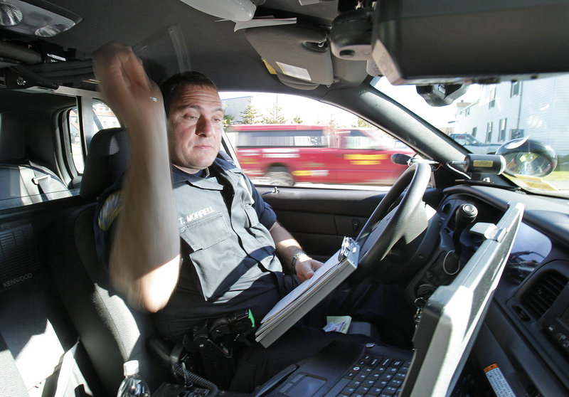 Officer Tim Morrell looks at information on his computer while writing a speeding ticket Thursday on Main Street in Westbrook, where police have stepped up speed enforcement.