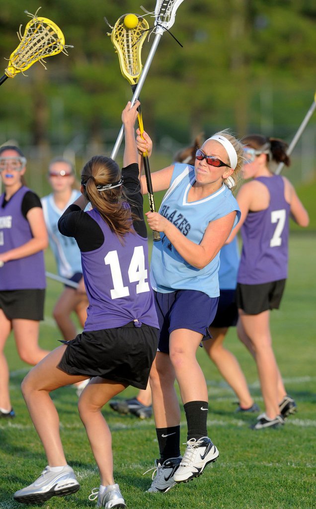 Katie Conley, right, of Westbrook fires a shot over Deering’s Ursula Donovan to score a goal in the Blue Blazes’ 6-5 win.