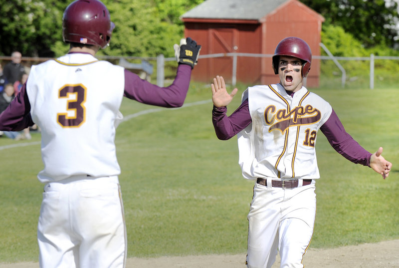Rob Macdonald, who pitched a one-hitter for Cape Elizabeth, is met at the plate by Cam Brown after scoring in the third inning Friday. The Capers remained undefeated with a 5-1 victory at home against York.