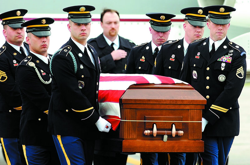 Maine Army National Guard soldiers move the casket containing Spc. Wade Slack’s remains from a Falcon 20 charter jet to a waiting hearse Friday morning at the Augusta State Airport.