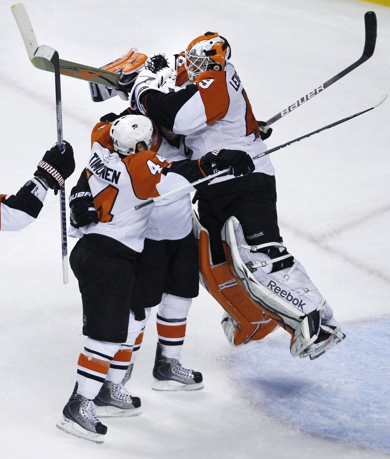 Philadelphia goalie Michael Leighton jumps into the arms of Mike Richards, center, and Kimmo Timonen after the Flyers completed their epic comeback Friday night with a 4-3 victory against the Boston Bruins.