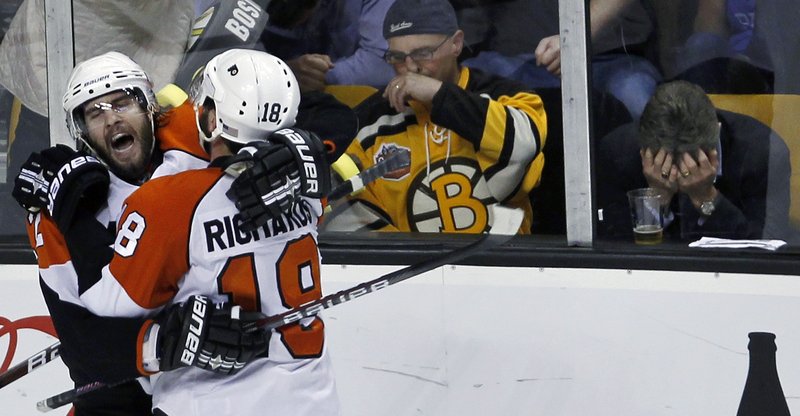 While some fans couldn’t bear to watch, Simon Gagne of the Philadelphia Flyers, left, is congratulated by Mike Richards after scoring the power-play goal in the third period that polished off the Boston Bruins’ utter collapse.