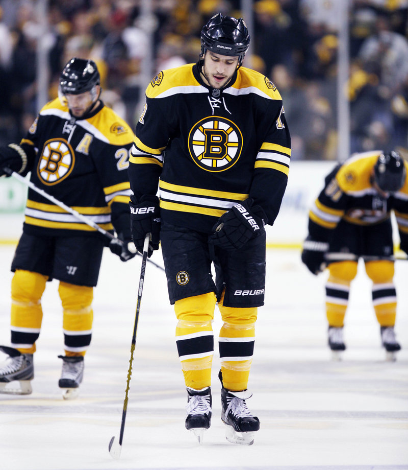Milan Lucic, center, Blake Wheeler, left, and Marc Savard leave the ice after Friday’s stunning loss to the Flyers. The Bruins blew 3-0 leads in the series and Game 7.