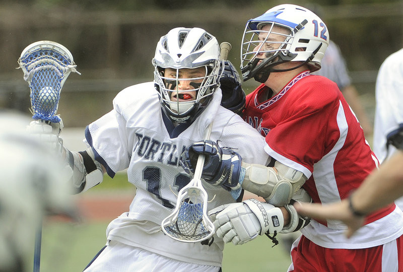 Caleb Kenney of Portland attempts to charge past Jacob Erskine of Messalonskee during their schoolboy lacrosse game Saturday at Fitzpatrick Stadium in Portland. In a game between unbeaten teams, Portland came away with a 14-11 victory.