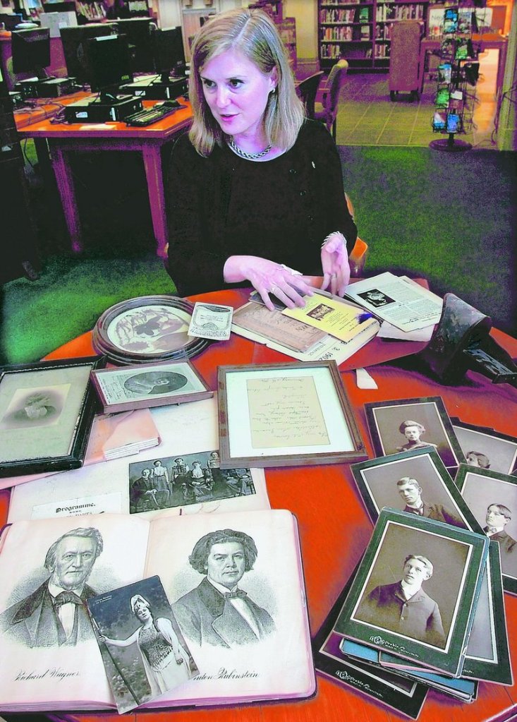 Sarah Sugden, director of the Waterville Public Library, arranges some of the materials, including documents and photographs, that have been discovered at the library during the renovation process.