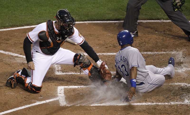 Alberto Callaspo of the Royals beats the tag by Orioles catcher Matt Wieters to score in the fifth inning Tuesday night in Baltimore. The Orioles won 4-3 in 10 innings.