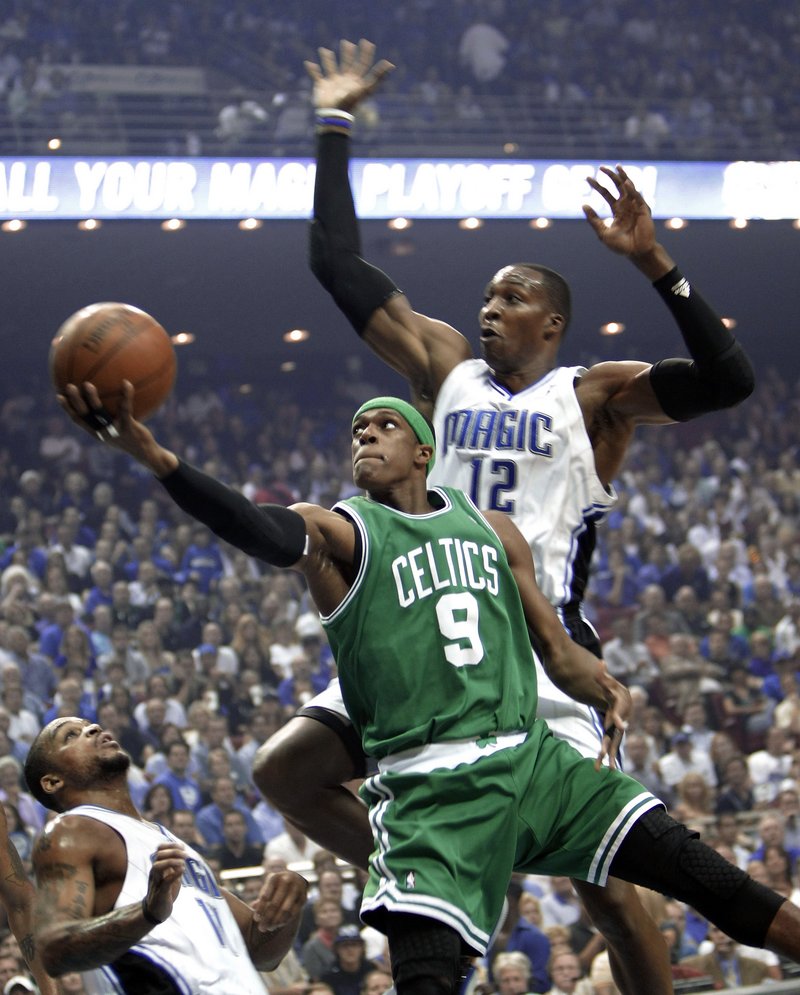 Rajon Rondo of the Celtics, left, does it again, scoring 25 points to help Boston slip by Dwight Howard and the Magic 95-92 on Tuesday night. Howard scored 30 points.