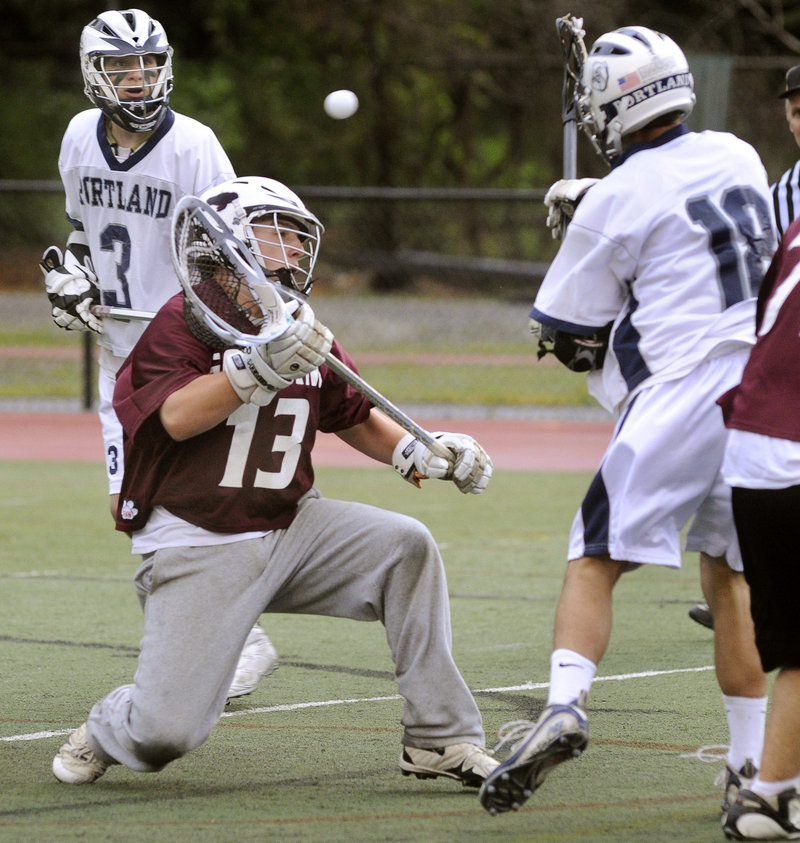 Bronson Guimond, right, of Portland flips a shot past Gorham goalie Nate Hollaran for one of his four goals Wednesday night in an 18-4 boys lacrosse victory at Fitzpatrick Stadium.