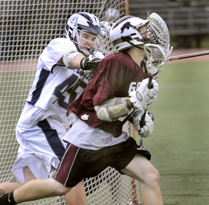Luc Robitaille, right, of Gorham cradles the ball as he's chased by Portland's Eddie Walsh during Wednesday night's game. Robitaille scored for the Rams in an 18-4 loss.