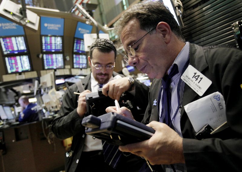 Richard Scardino, left, and Sal Suarino work on the floor of the New York Stock Exchange Thursday. A large drop on Wall Street was not seen as the result of a single factor, but tied to growing concern about Europe’s economic stability.