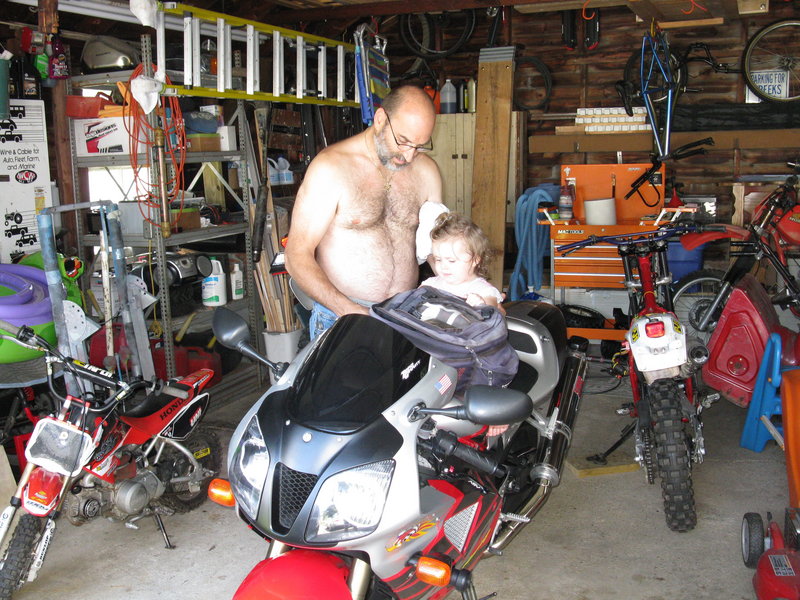 Joseph Moustrouphis puts his granddaughter Hailey on the seat of one of his bikes.