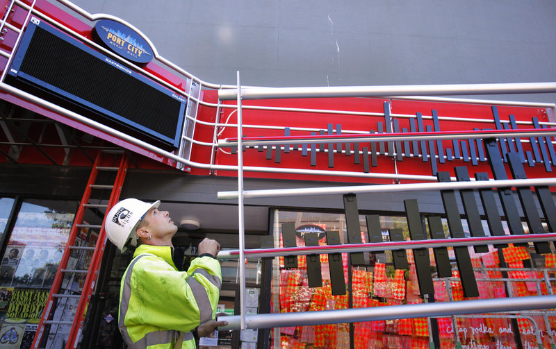 Josh Boyd of Burr Signs guides a section of the new marquee at Port City Music Hall in Portland on Friday. The city pitched in $18,000 of a federal grant as part of an effort to beautify the Congress Streets Arts District.