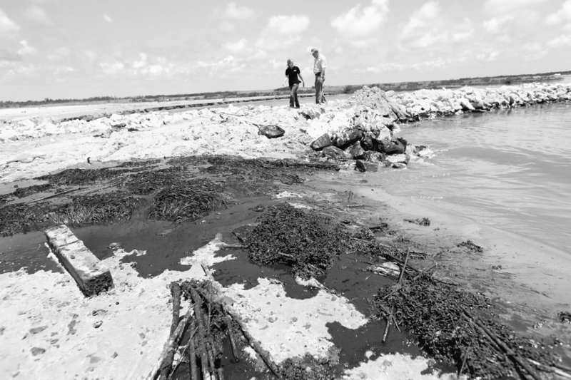 Oil washes ashore against a land bridge built by the Louisiana National Guard to hold back oil from the Deepwater Horizon oil spill in Grand Isle, La., on Friday.