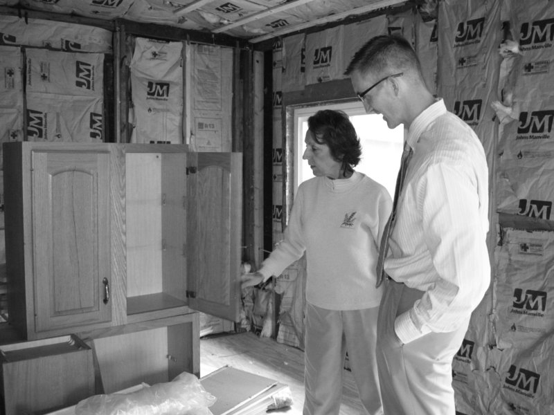 Pat Frechette, left, of the Fuller Center, and Jeff St. Laurent, loan officer at Saco & Biddeford Savings Institution, inspect new cabinets that will be installed in a home by the Southern Maine Fuller Center.