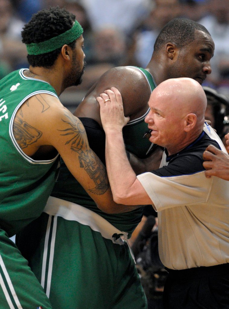 Rasheed Wallace, left, and referee Joe Crawford assist Glen Davis after he was hit in the face by an inadvertent elbow Wednesday night against Orlando, suffering a concussion.