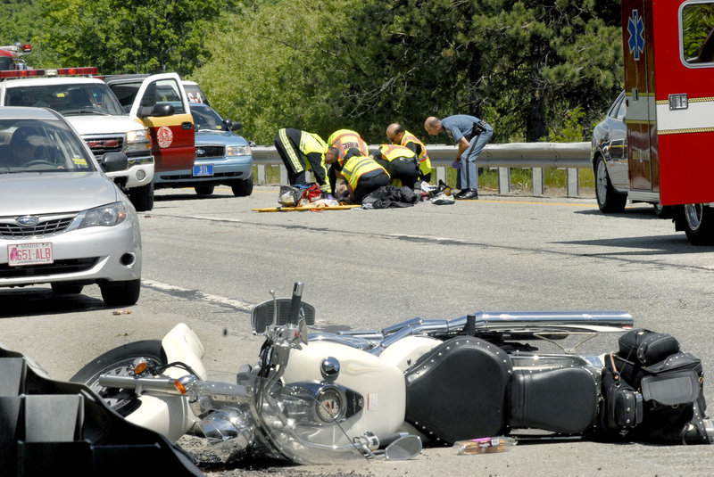 Paramedics and state troopers attend to a motorcyclist who hit a guardrail on Interstate 95 in Augusta on Friday. Delmer Maxwell, 60, was flown by a LifeFlight helicopter to a Lewiston hospital with serious injuries.