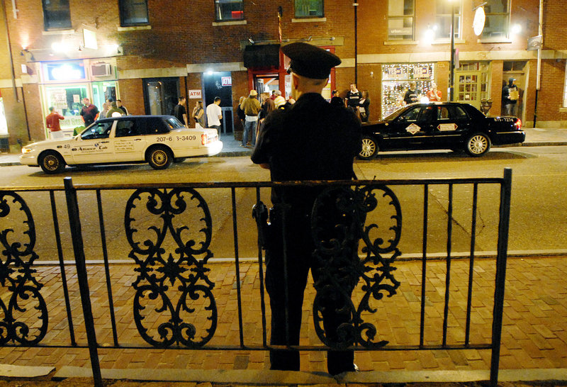 Portland Police Officer Evan Bomba watches the action in the Old Port on Friday night from his perch on Fore Street. “Having these guys here makes you feel better,” said one young woman as she walked by.