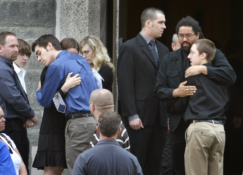 Friends and family console each other at the funeral for Eric Benson at St. Hyacinth’s Church of St. Anthony’s Parish in Westbrook on Saturday. Police have charged William Googins, 20, with manslaughter in the early May 23 attack in Portland’s Monument Square.