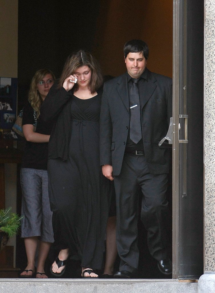 Andrew Benson and other mourners exit St. Hyacinth’s Church in Westbrook following the funeral for his twin brother, Eric Benson, on Saturday.
