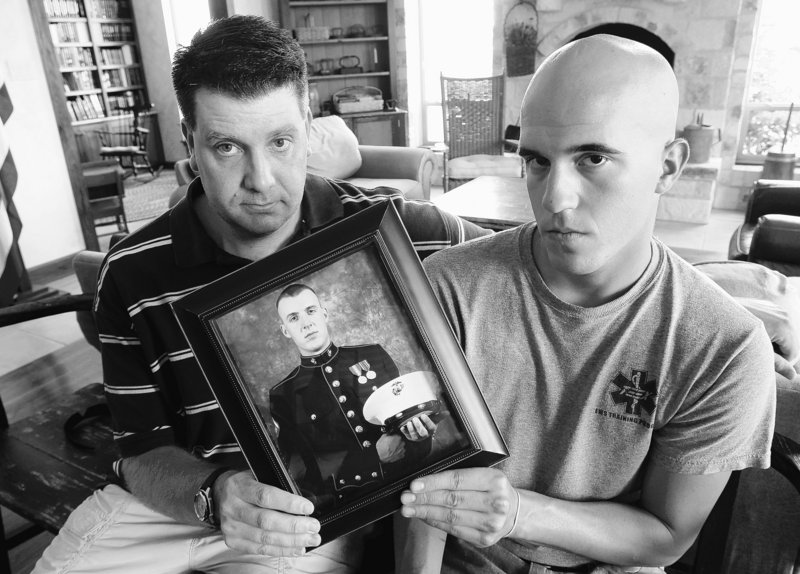Jonathan Leicht, left, and Jesse Leicht hold a photo of their brother, Marine Cpl. Jacob Leicht, on Saturday in Kerrville, Texas. Jacob Leicht was killed in Afghanistan on Thursday.