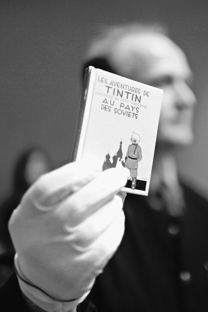 A porter displays an album of “Tintin au pays des soviets” drawn by Belgian creator Herge, during the auction of rare memorabilia of Tintin, at the Drouot-Montaigne auction house in Paris on Saturday.