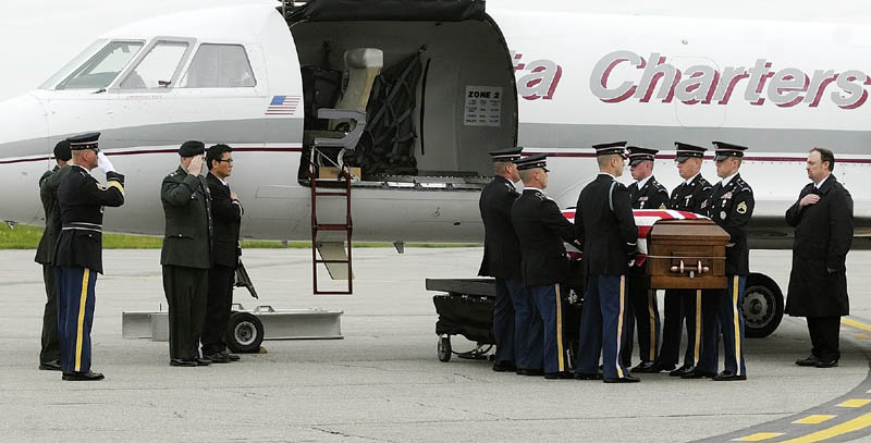 Staff photo by Joe Phelan Maine Army National Guard soldiers move the casket containing U.S. Army Spc. Wade A. Slack's remains from a Falcon 20 charter jet to a waiting hearse Friday morning at the Augusta State Airport. The motorcade then drove north to Waterville. sidney