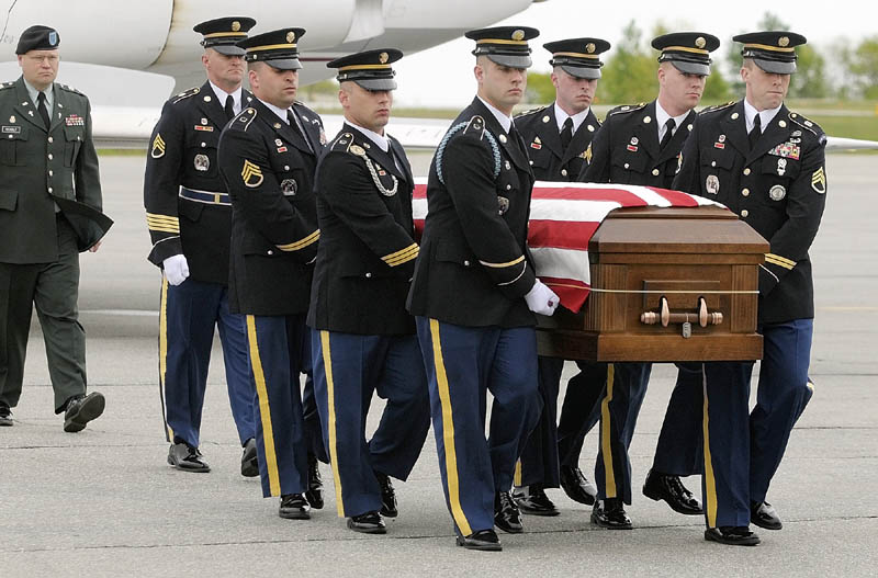 Staff photo by Joe Phelan Maine Army National Guard soldiers move the casket containing U.S. Army Spc. Wade A. Slack's remains from a Falcon 20 charter jet to a waiting hearse Friday morning at the Augusta State Airport. The motorcade then drove north to Waterville. sidney