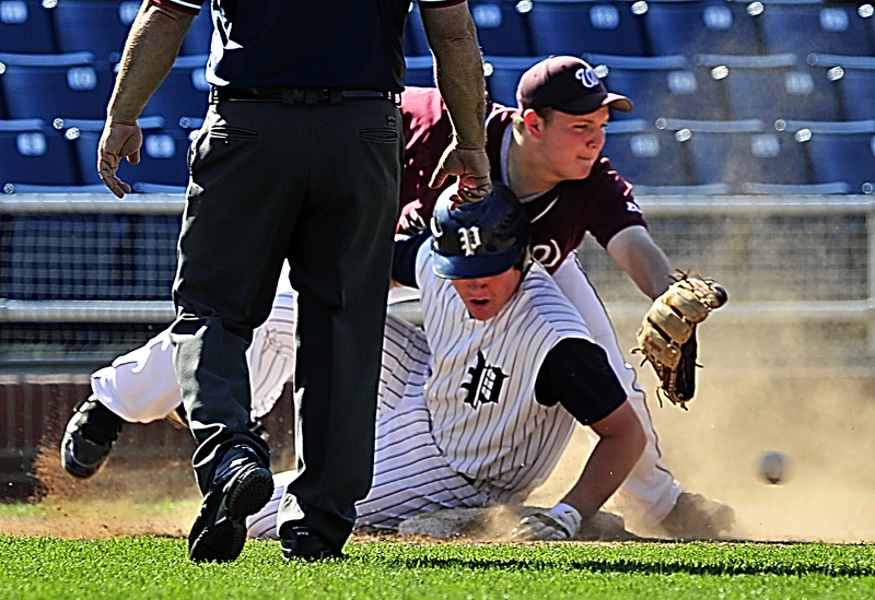 Scott Briggs of Portland slides safely into third base Tuesday as Robert Hamilton of Windham attempts to control a throw from the outfield during their Telegram League game at Hadlock Field. Windham scored four runs in the fifth inning for a 6-3 victory.