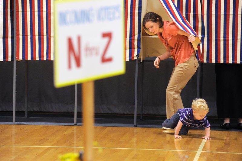 Cape Elizabeth voters cast their ballets at Cape Elizabeth High School on Tuesday morning. Two year old Toby Noonan makes his break from a voting booth his mom, Gretchen Noonan, was voting at. (Photo by JohnEwing/ Staff photographer)