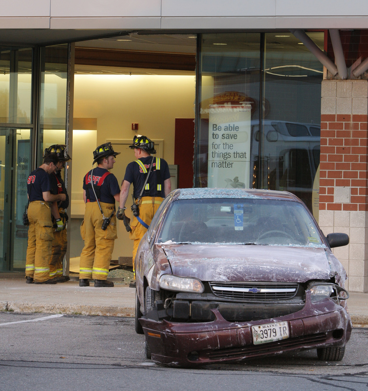 A Chevy Malibu sits near the entrance of the Bank of America at 50 Market St. in South Portland on Monday evening. The car crashed through a window and then partially through an interior wall near the ATM. The driver got his foot stuck on the gas pedal, police said.