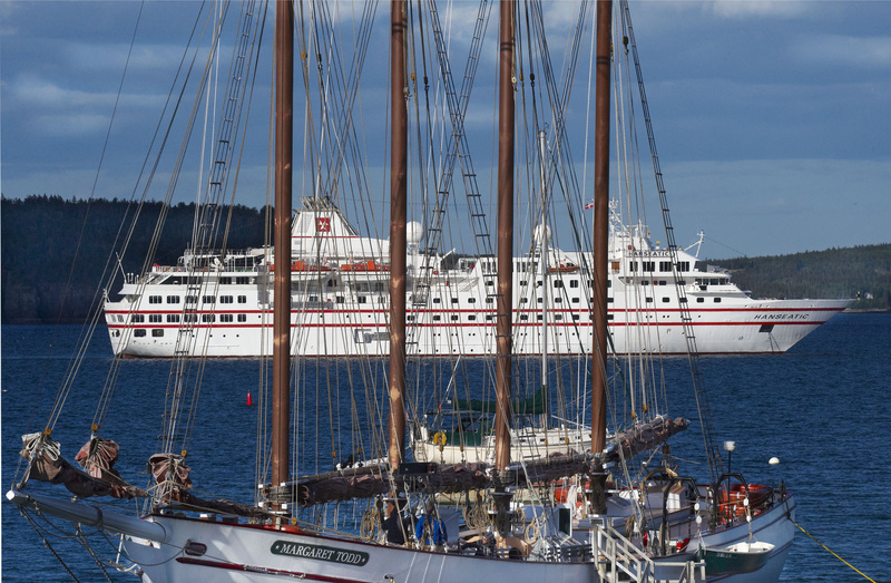 The four-masted schooner Margaret Todd sits at berth while the cruise ship Hanseatic sits at anchor in Bar Harbor on May 27. Bar Harbor expects 119 cruise ship visits this year, compared with only 39 visits 11 years ago.