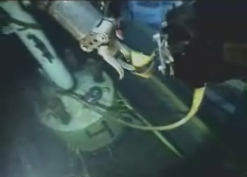 In this image from video made available by British Petroleum, a robot submarine prepares the capping device, lower left, early today.