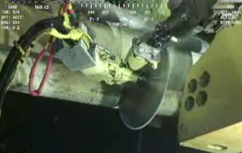 In image made from video released by British Petroleum, robot submarines use a circular saw-like device to cut a pipe at the Deepwater Horizon oil rig.