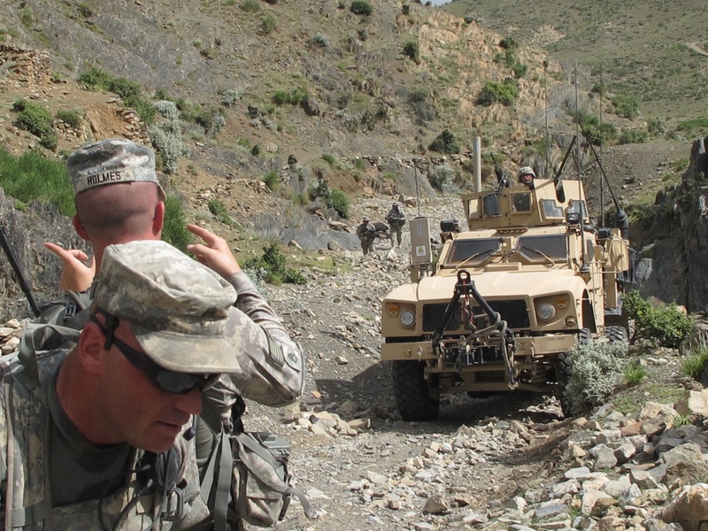 Staff Sgt. Joshua Holmes of Lisbon Falls guides a Bravo Company vehicle up a "wadi," or dry riverbed, in a remote valley of eastern Afghanistan. In the foreground is Sgt. Frederick Moody of Gorham.