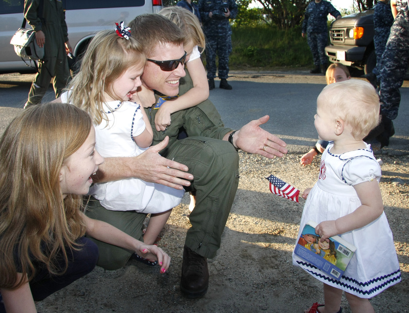 Lt. Cmdr. Greg Smith of Brunswick is welcomed home by his daughters, from left, Madeline, 11, Mary, 3, Riley, 8, and Rhyse, 1, at the Portland International Jetport. Smith is a member of VP-26, a Navy squadron that flew out of Brunswick Naval Air Station on Nov. 28 and returned Monday after a six-month deployment in Europe, Africa and Central America.