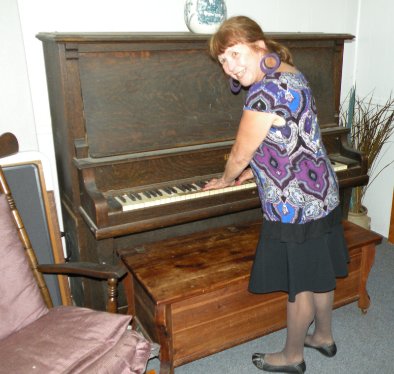Marilyn Lacombe Snipe poses with an antique piano once played at Waterville’s Bijou Theater during silent movies.