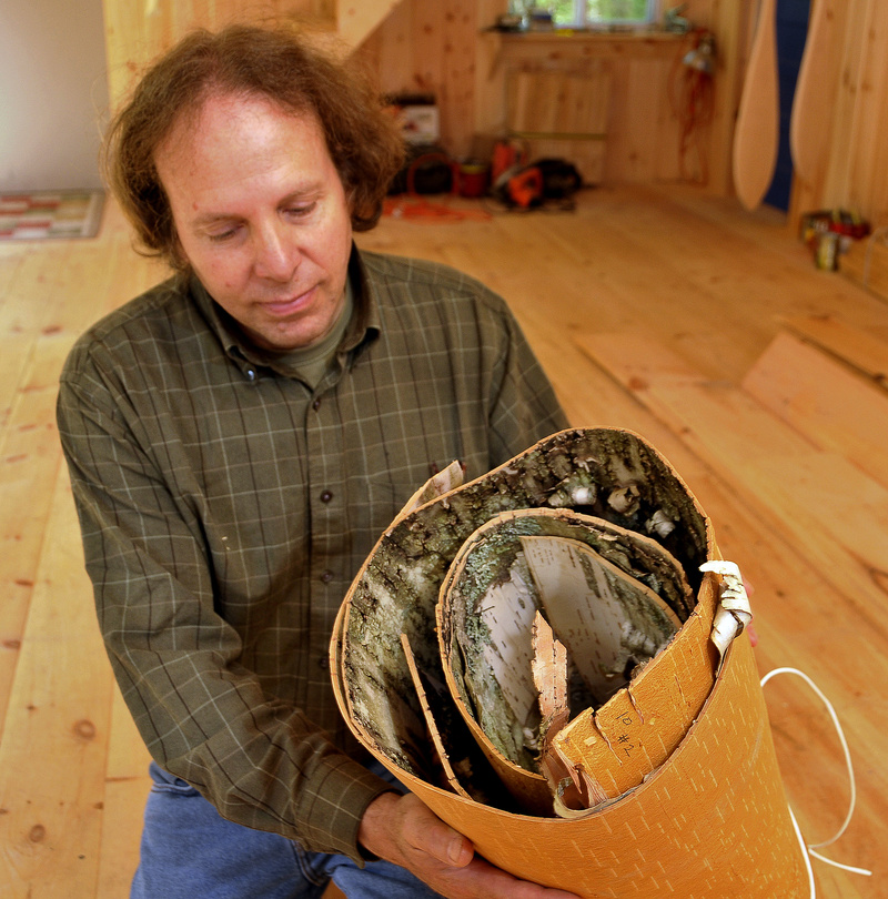 Steve Cayard shows a roll of winter bark he uses to build bark canoes. It will be soaked and used to cover a cedar frame.