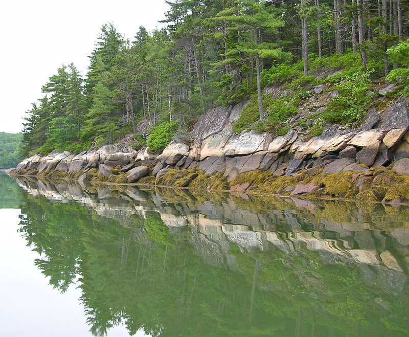 Reflections of the rocky shoreline in The Basin, a multi-fingered tidal cove in Phippsburg, are especially beautiful on a cloudy, calm day.