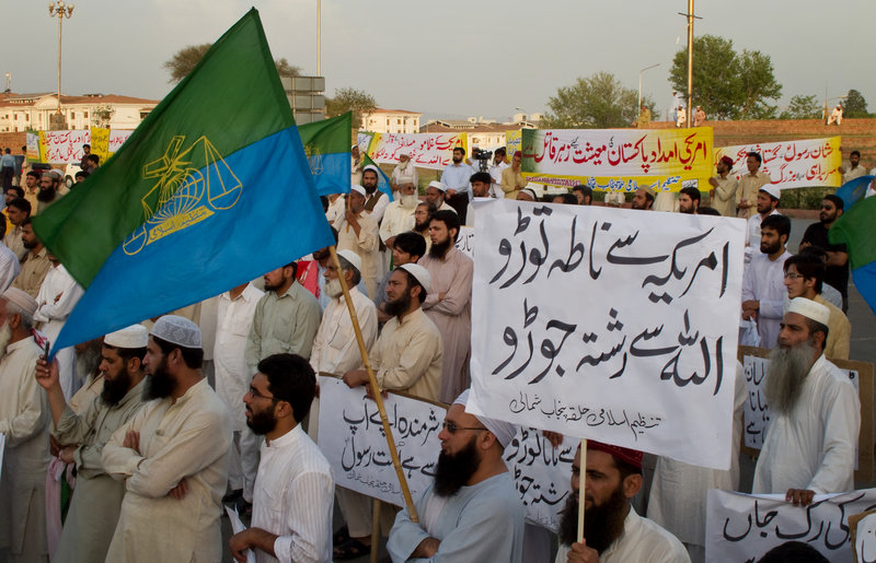 Supporters of Tanzeem-e-Islami, a Pakistani religious party, listen at a rally against a Facebook page in Islamabad, Pakistan, on Saturday. The placard at front right reads: “Disconnect relations with America and connect with God.”